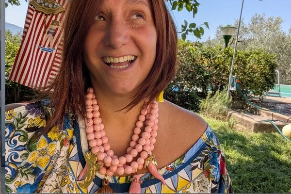 Pink ceramic necklace from Naples worn with a printed linen kaftan